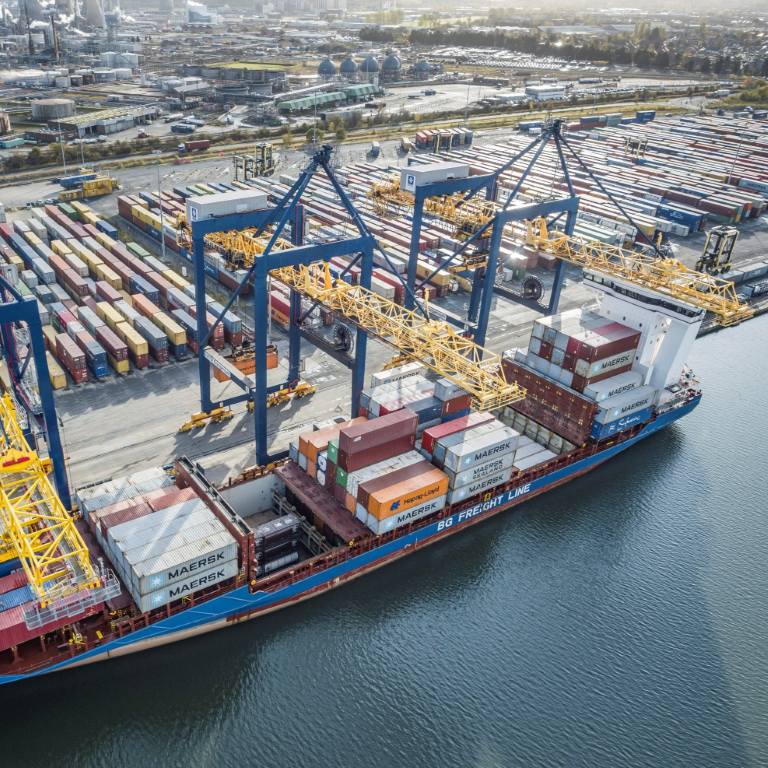 A container vessel berthed at Grangemouth Port being offloaded by crane